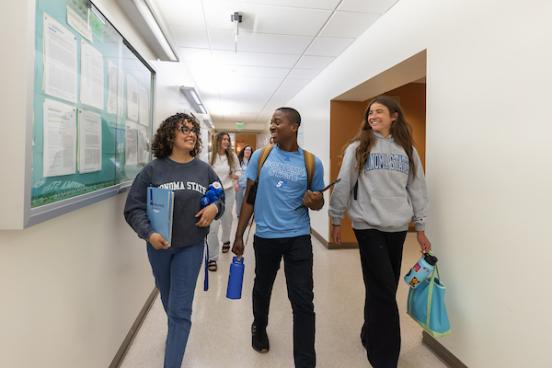 Three Students Walking Down the Hallway