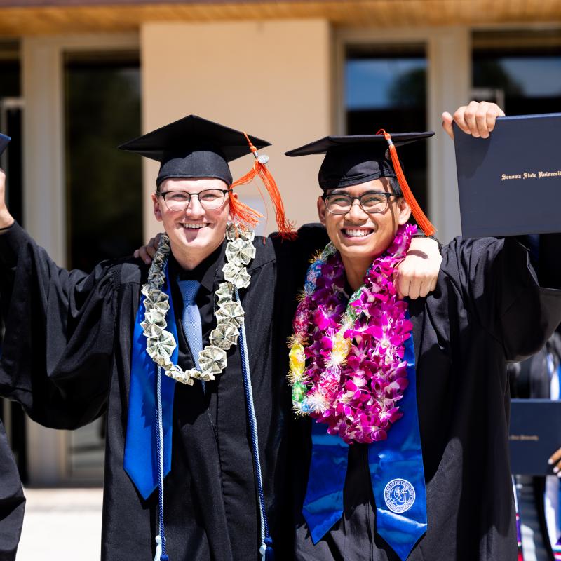 Two happy graduates at commencement 