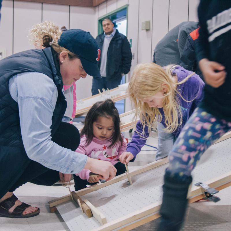 students working with young learners on a project 